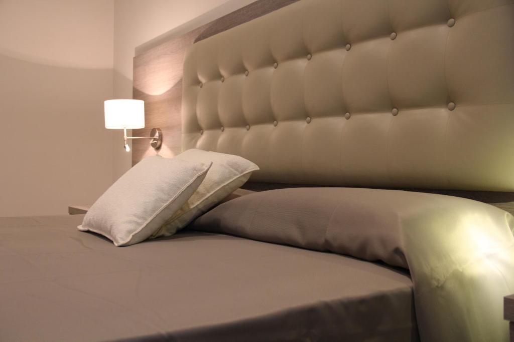 a bed with a large headboard in a bedroom at Hotel Delle Canne in Amantea