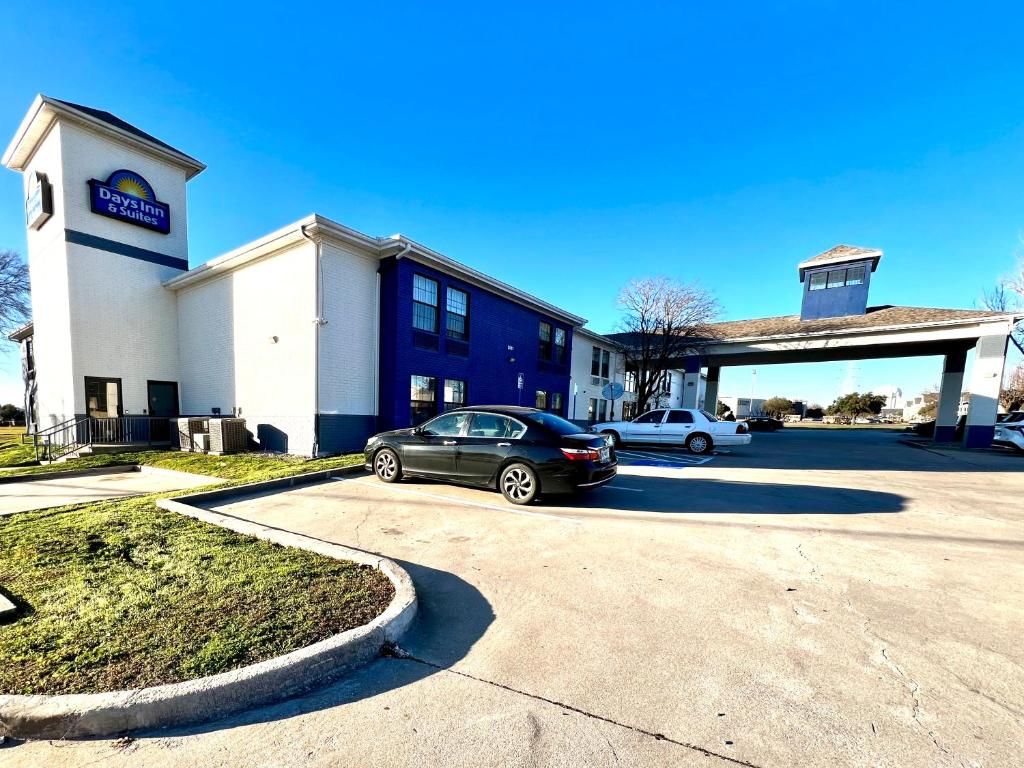 a car parked in front of a building at Days Inn by Wyndham Dallas Plano in Plano