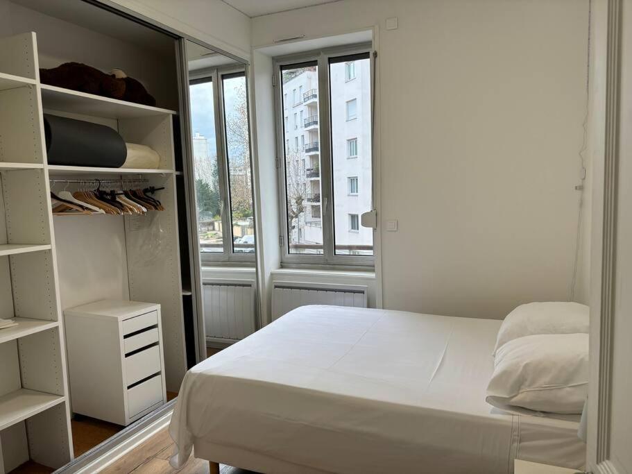 - une chambre blanche avec un lit et une fenêtre dans l'établissement T2 à louer à Villeurbanne, à Villeurbanne