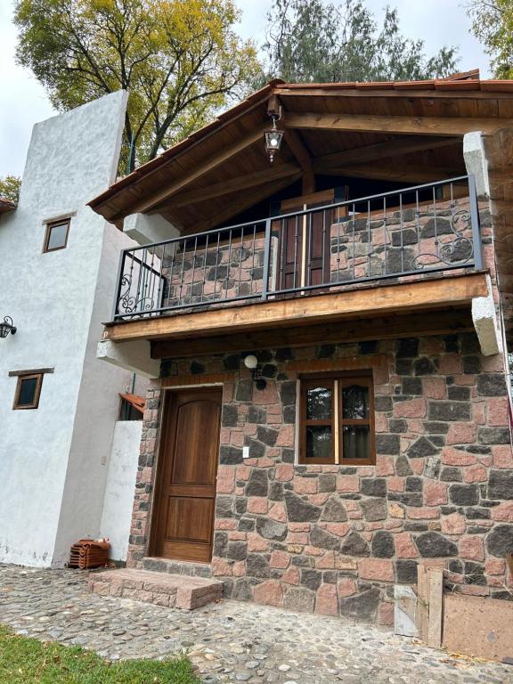 a house with a balcony on top of it at Cabañas del Bosque in San Miguel Regla