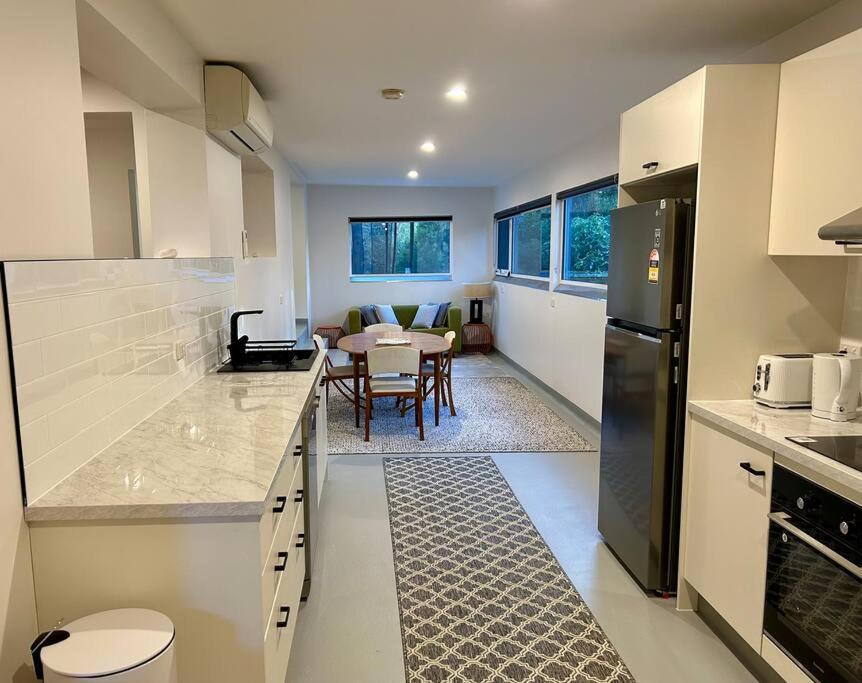 eine Küche mit einem Tisch und einem Esszimmer in der Unterkunft Stylish Sandy Bay Apartment in Sandy Bay