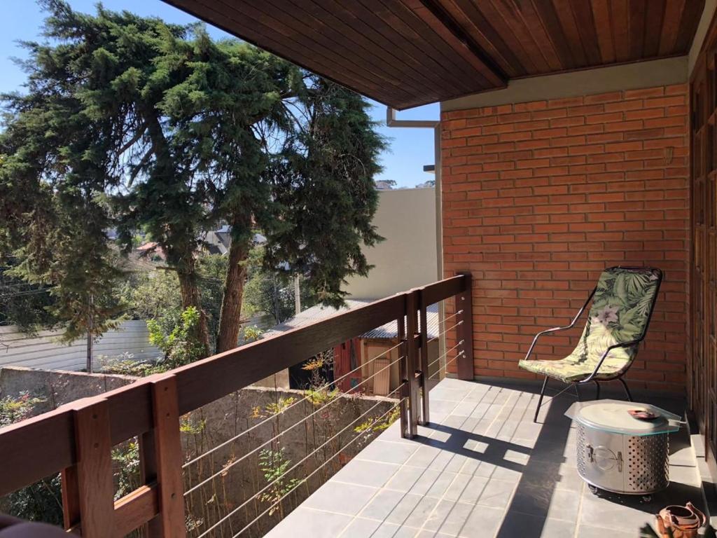 un patio con una silla y un árbol en el porche en Studio Carini, en Curitiba