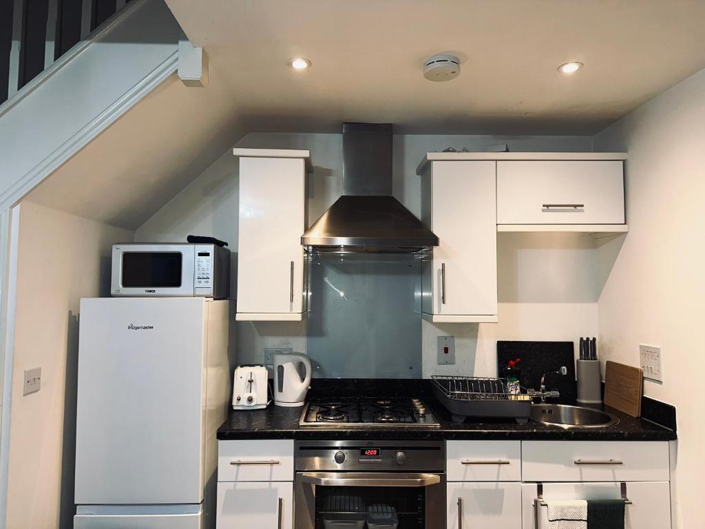 una cucina con piano cottura e forno a microonde di Guest House Nikol a Sherborne Saint John