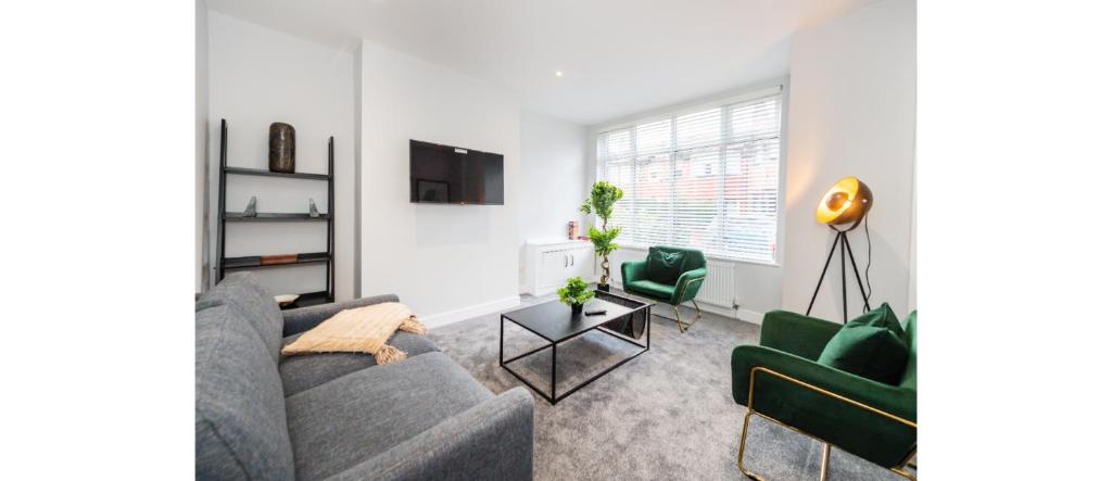 a living room with a couch and two green chairs at Hassle-Free & Handsome Brand-New 3-Bed Home in Manchester