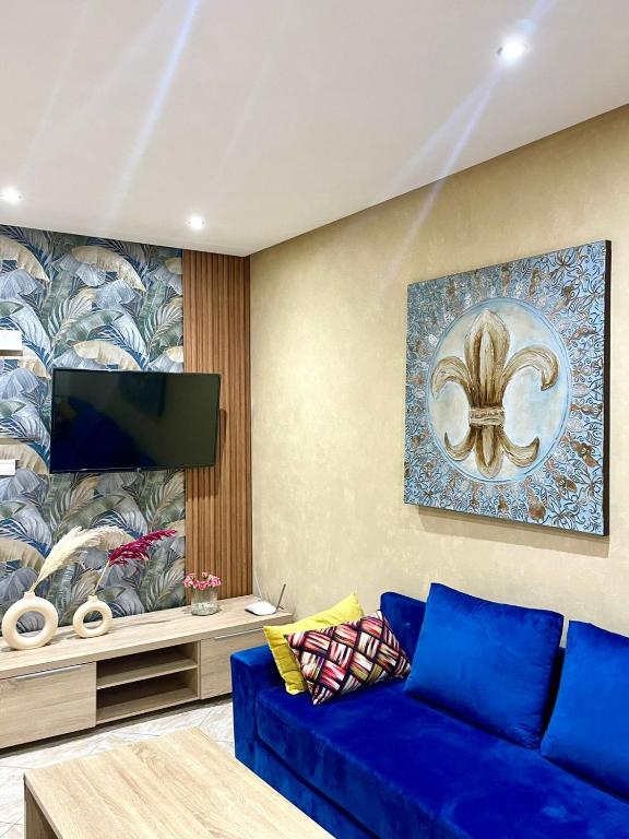 a living room with a blue couch and a tv at Luxurious Apartment Center Agdal Rabat in Rabat