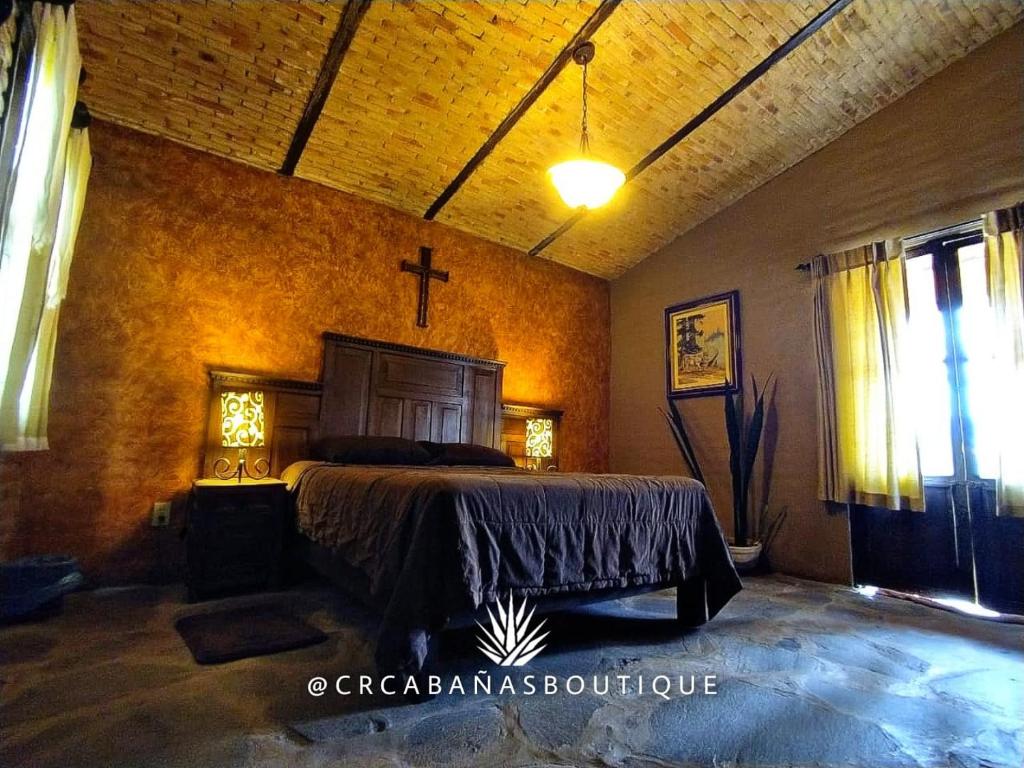 a bedroom with a bed and a cross on the wall at Casona de mis Recuerdos in Ahualulco de Mercado