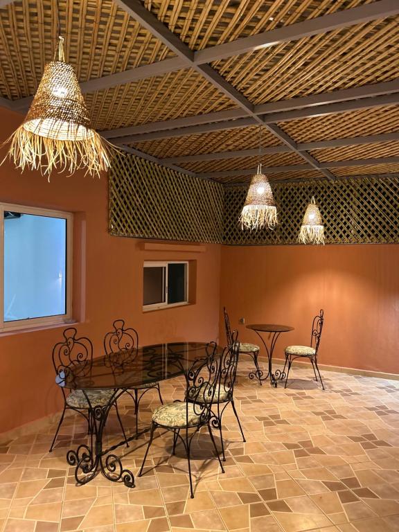 a dining room with a table and chairs and lights at Appartement Duplex élégant et calme Marrakech Menara in Marrakesh