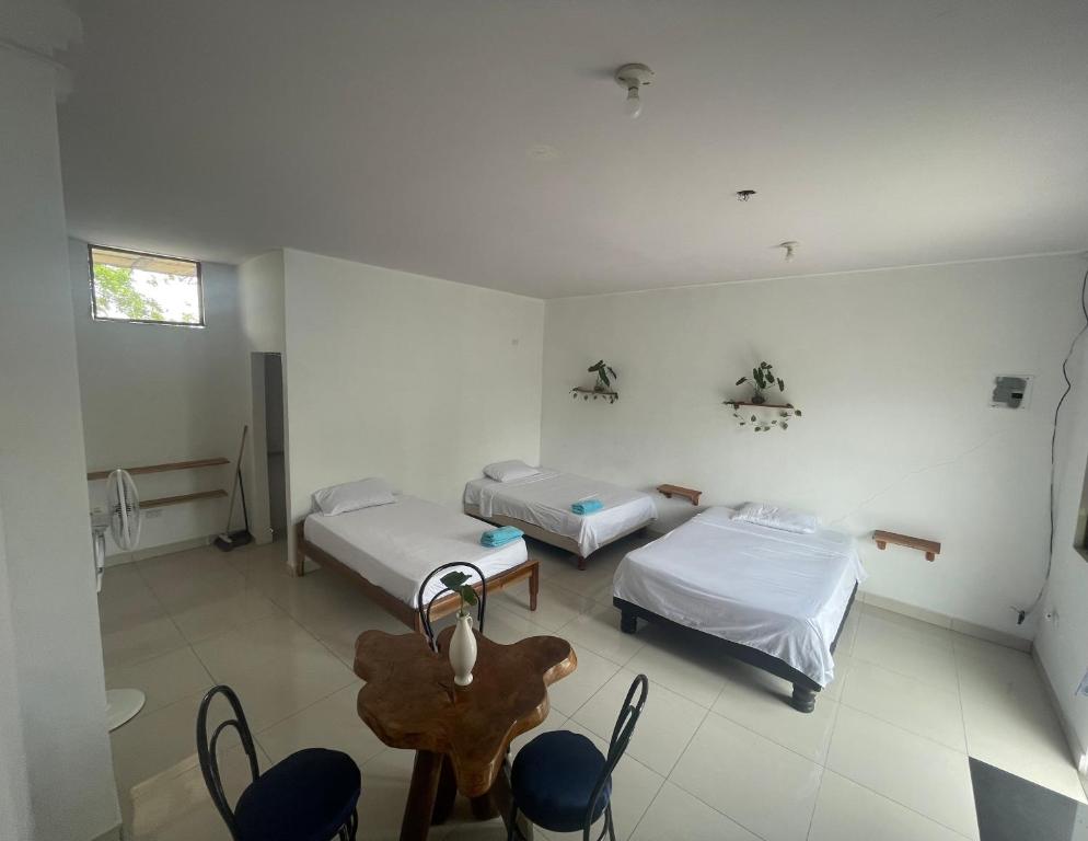 a room with two beds and a table and chairs at habitación cerca a playa man in San Cristobal