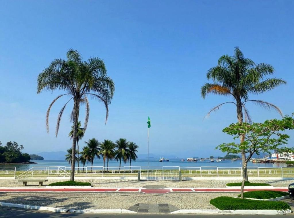 un grupo de palmeras sentadas junto al agua en Suíte Félix Praia do Anil Angra dos Reis, en Angra dos Reis