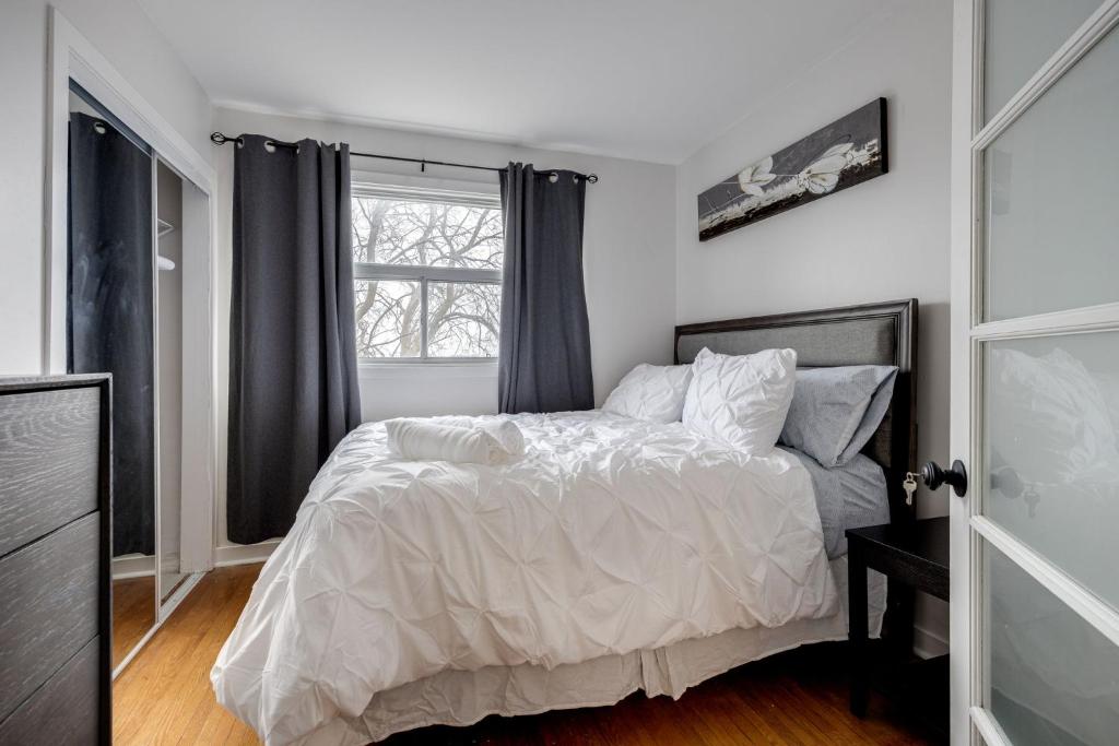 a bedroom with a bed and a window at Eglinton West Guest Suite in Toronto