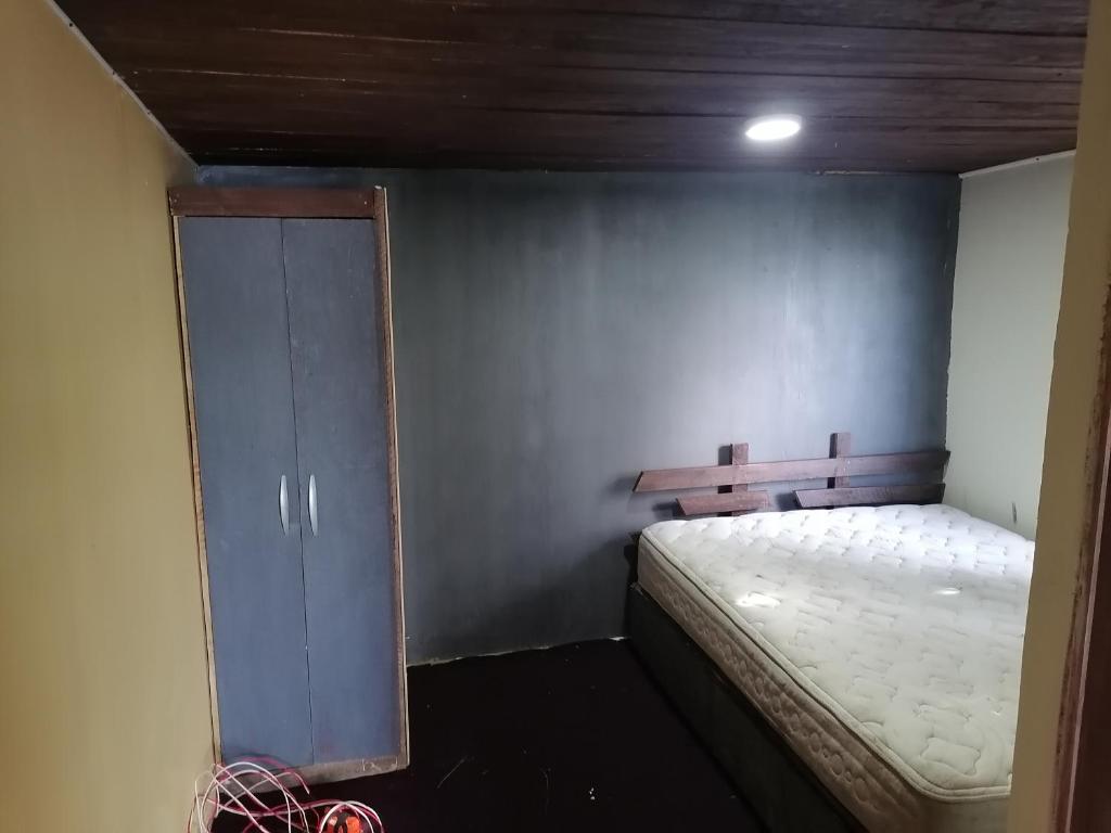 Kleines Zimmer mit einem Bett und einem Schrank in der Unterkunft Eden in Queilén