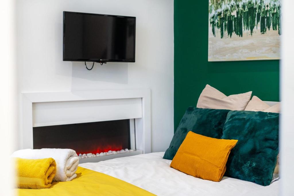 a bedroom with a bed with a tv and a fireplace at The Green Room in Sydenham