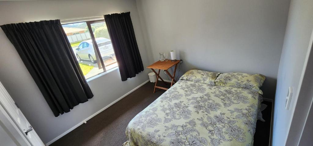 a small bedroom with a bed and a window at A room in a homestay in Upper Hutt