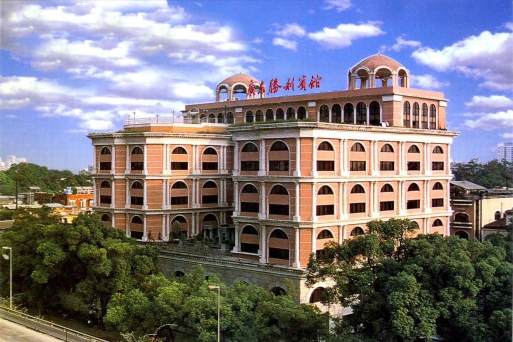 
a large building with a clock on the front of it at Guangdong Victory Hotel in Guangzhou

