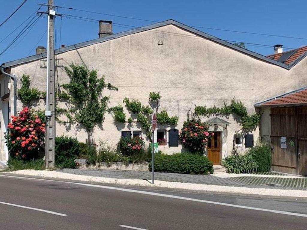 a white building with flowers on the side of a street at Gîte Buxières-sous-les-Côtes, 6 pièces, 10 personnes - FR-1-585-7 in Buxières-sous-les-Côtes