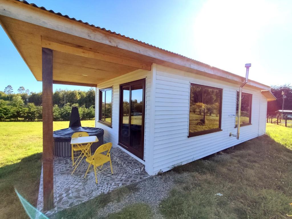 a white tiny house with a table and chairs at Casa Rayen Puerto Varas in Puerto Varas