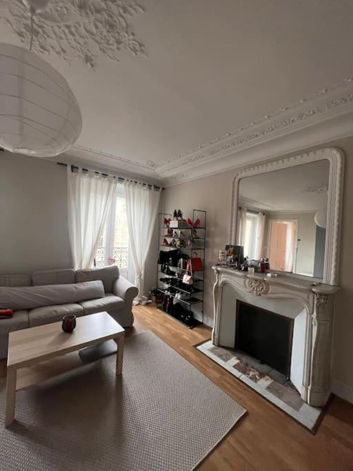 un salon avec un canapé et une cheminée dans l'établissement Central Parisian Apartment, à Paris