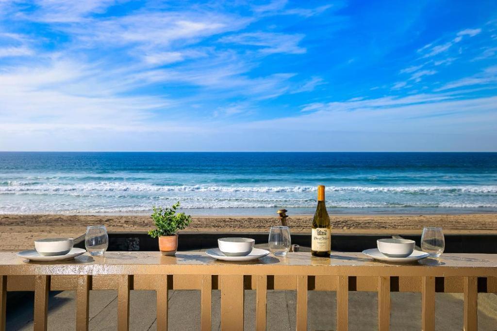 einen Tisch mit einer Flasche Wein und Gläsern am Strand in der Unterkunft Stunning Ocean Views - Recently Renovated Home & Warm Sunsets in San Diego