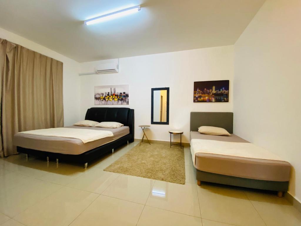 sypialnia z 2 łóżkami i dywanem w obiekcie Alyn Home Kluang I Netflix Wifi Coway w mieście Kluang