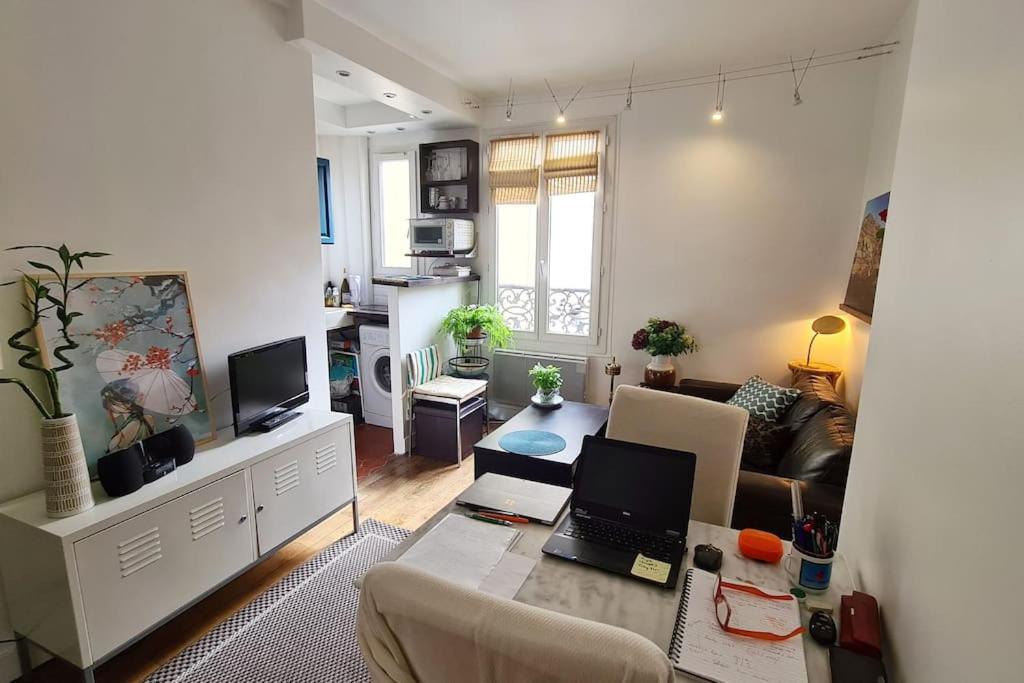 un salon avec un canapé et un ordinateur portable sur une table dans l'établissement Logement entier - 2B/R 3 min de Butte aux cailles, à Paris