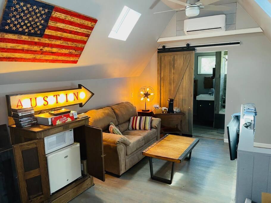 salon z kanapą i amerykańską flagą w obiekcie Bastrop Tiny Disc Golf Retreat w mieście Bastrop