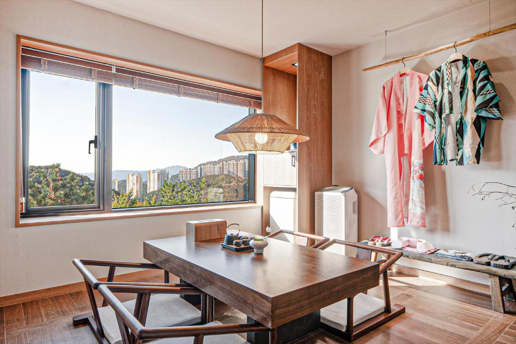 a dining room with a table and a window at Mandeok Denbasta Ryokan in Busan