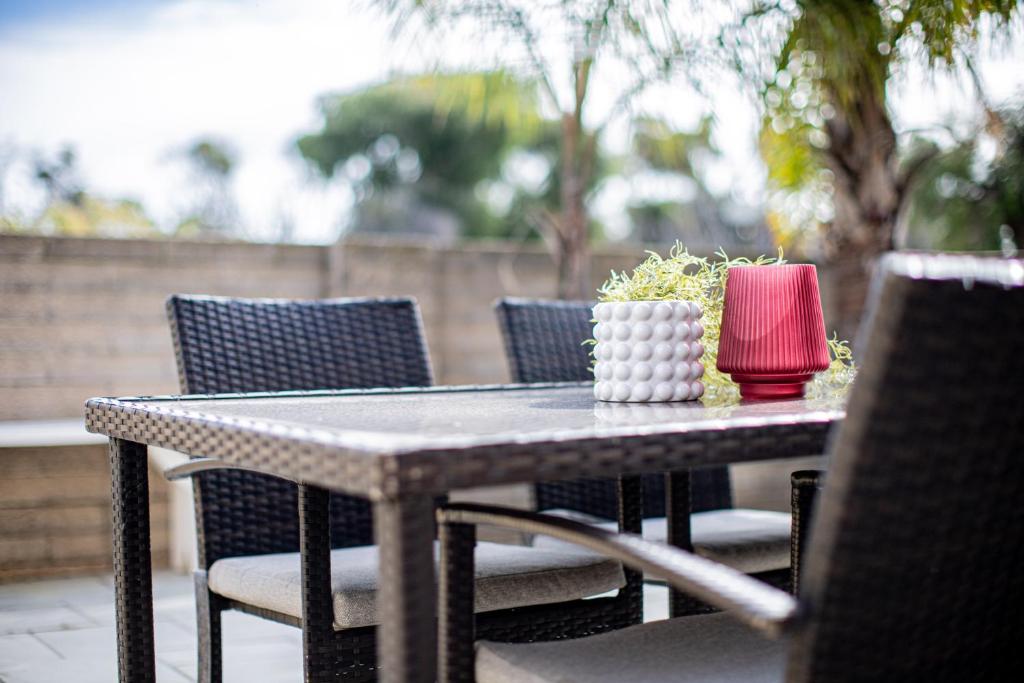 d'une table de patio avec des chaises et une serviette rouge. dans l'établissement Rockingham Beach Breeze 2br Retreat, à Rockingham