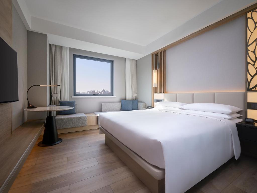 Postel nebo postele na pokoji v ubytování Courtyard By Marriott Shanghai Xujiahui