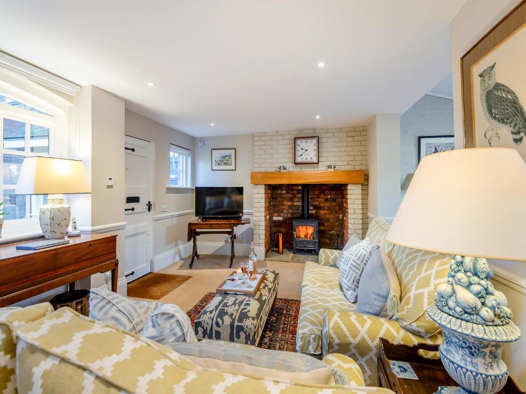 a living room with a couch and a fireplace at The Stables in Crockham Hill