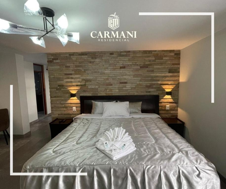 un grande letto in una stanza con muro di mattoni di RESIDENCIAL CARMANI a Tacna