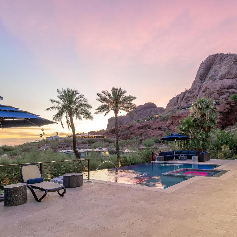 uma piscina de resort com palmeiras e uma montanha em Multi-Million Dollar Luxury Estate, Heated Pool, City Views em Phoenix