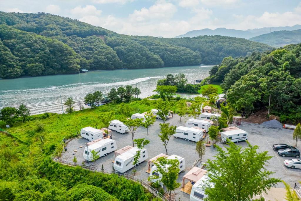 Chuncheon Healing Bridge في تشنتشون: اطلالة جوية لمجموعة من الجمال تقف بجانب نهر