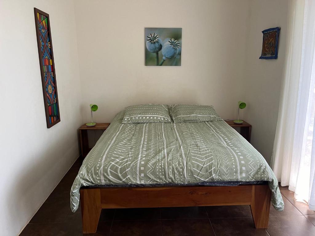 ein Bett in einem Schlafzimmer mit zwei Nachttischen und zwei Tischen in der Unterkunft El nido del tucán in Torio