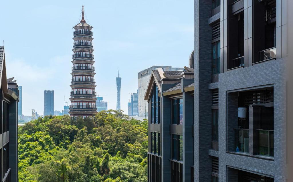 Livetour Hotel Pazhou Exhibition Center Guangzhou في قوانغتشو: اطلالة على مدينة فيها مباني واشجار طويلة
