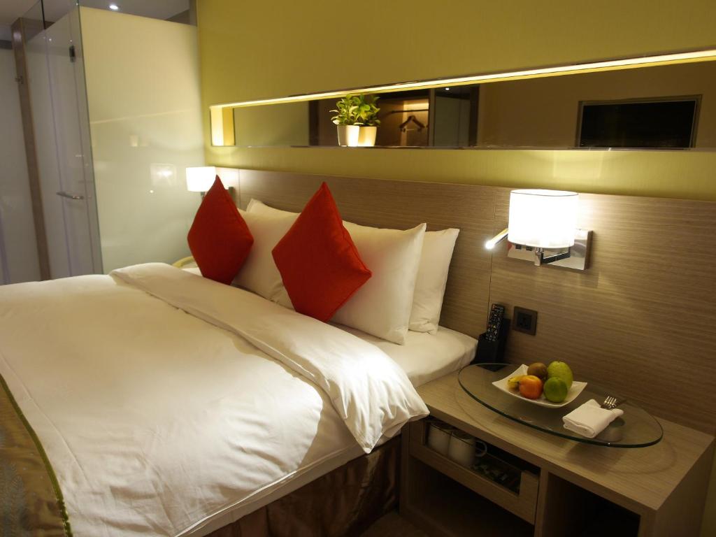 a bedroom with a bed and a bowl of fruit on a table at Kaohsiung International Plaza in Kaohsiung