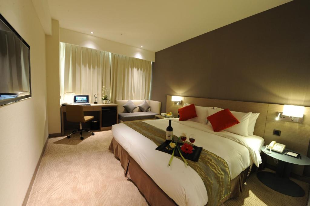 a hotel room with a large bed and a desk at Kaohsiung International Plaza in Kaohsiung