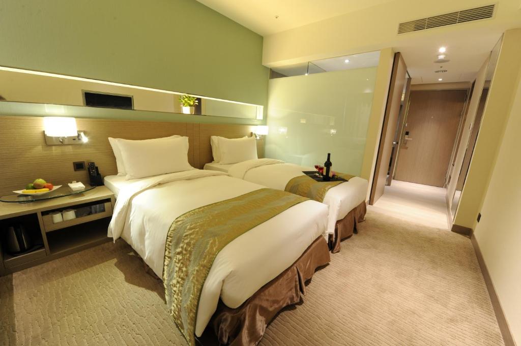 a hotel room with two beds and a bathroom at Kaohsiung International Plaza in Kaohsiung
