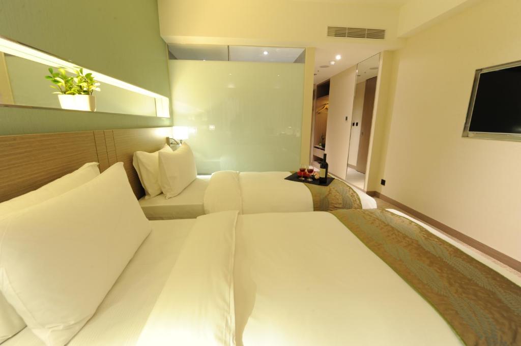a hotel room with a white bed and a television at Kaohsiung International Plaza in Kaohsiung