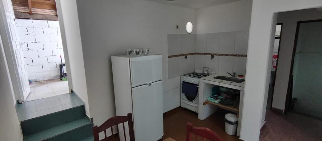 a small kitchen with a white refrigerator and a sink at Casa Ana 3 departamento a 20 min del aeropuerto de ezeiza in Luis Guillón