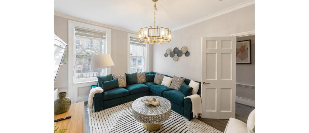 a living room with a blue couch and a table at Serenity in the City: Best 5BR Home in Whitechapel in London