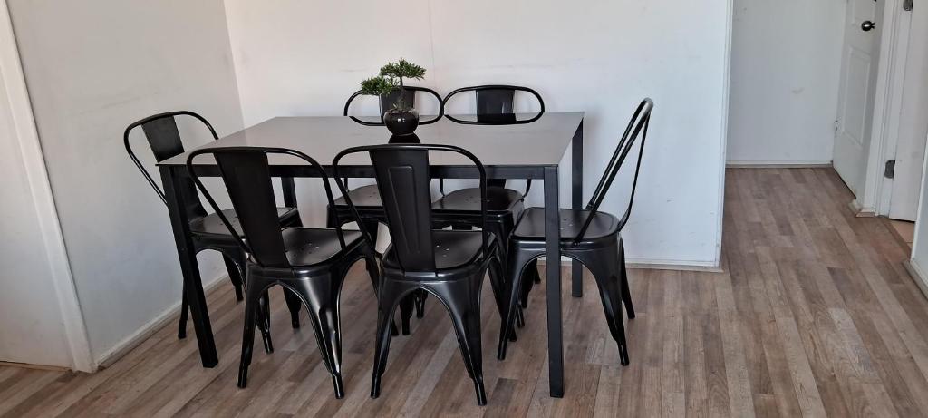 una mesa de comedor negra con sillas negras en Departamento cerca de Av. del Mar La Serena, en La Serena