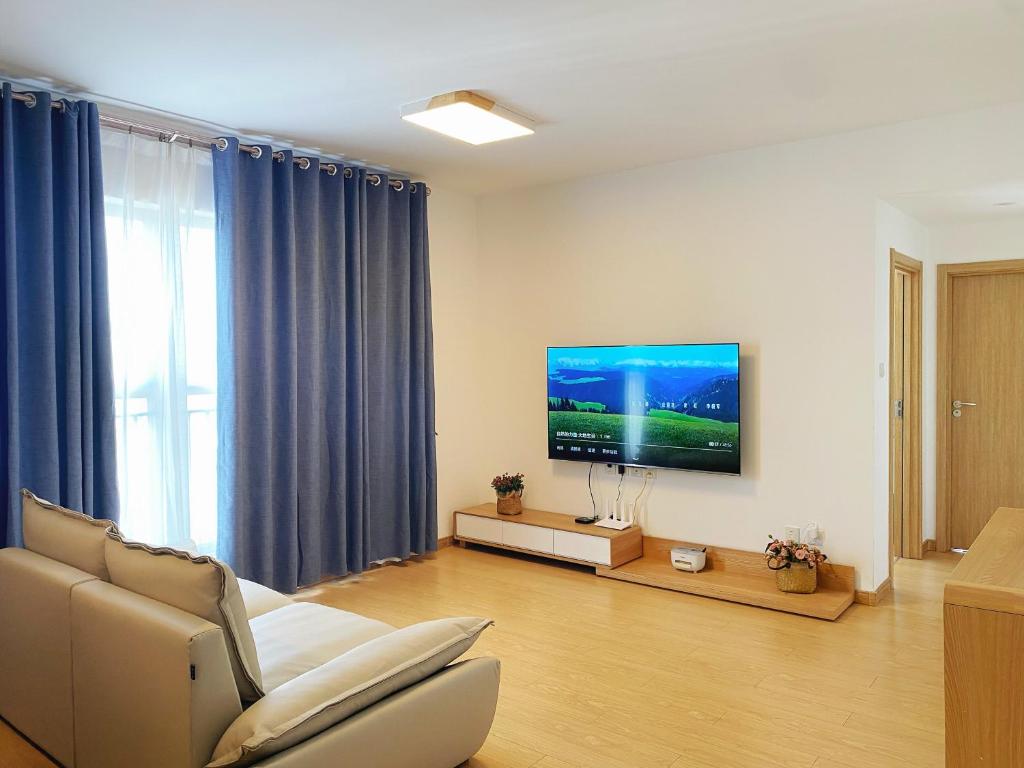 uma sala de estar com um sofá e uma televisão de ecrã plano em Inn Yuiko em Dali