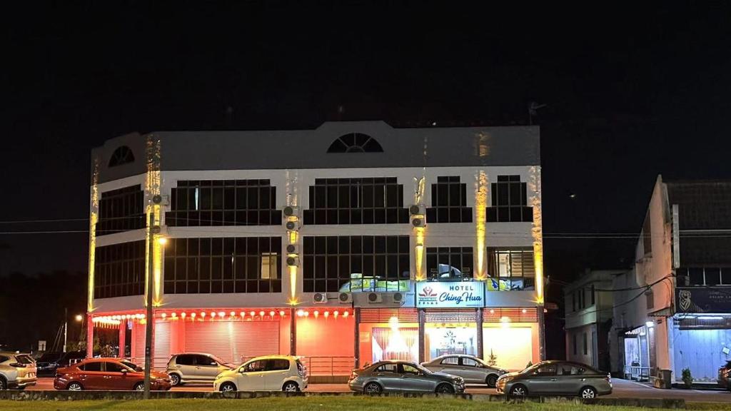 a building with cars parked in front of it at night at Hotel Ching Hua in Segamat