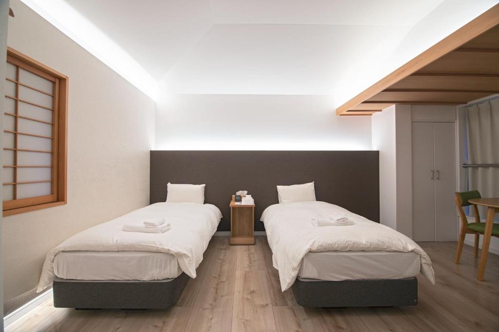 - une chambre avec 2 lits et des draps blancs dans l'établissement KyotoGosyonishi - Vacation STAY 25089v, à Kyoto