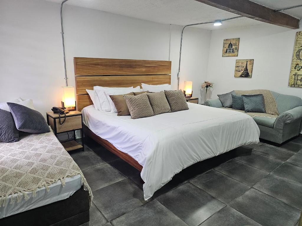 a bedroom with a large bed and a couch at Hotel Campestre Zona 7 cerca del aeropuerto en rioengro in Rionegro