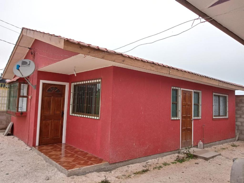 a red house with a red door at Cabañas doña carmen in Punta de Choros