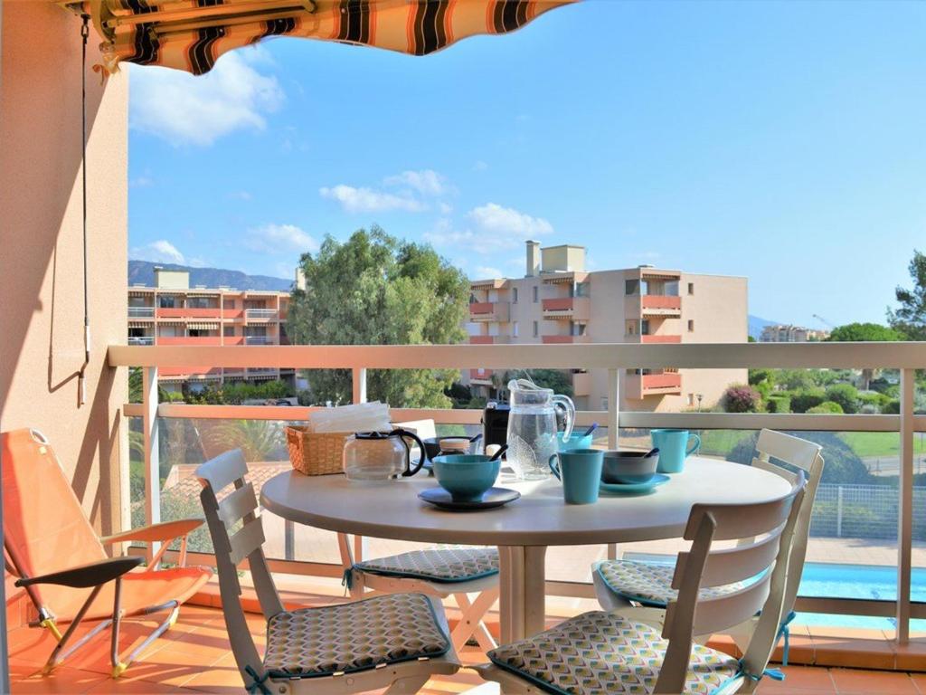 une table et des chaises sur un balcon avec vue dans l'établissement Studio cosy avec terrasse, piscine, tennis, Wi-Fi - Accès direct plage - Bormes-les-Mimosas - FR-1-251-560, à Bormes-les-Mimosas