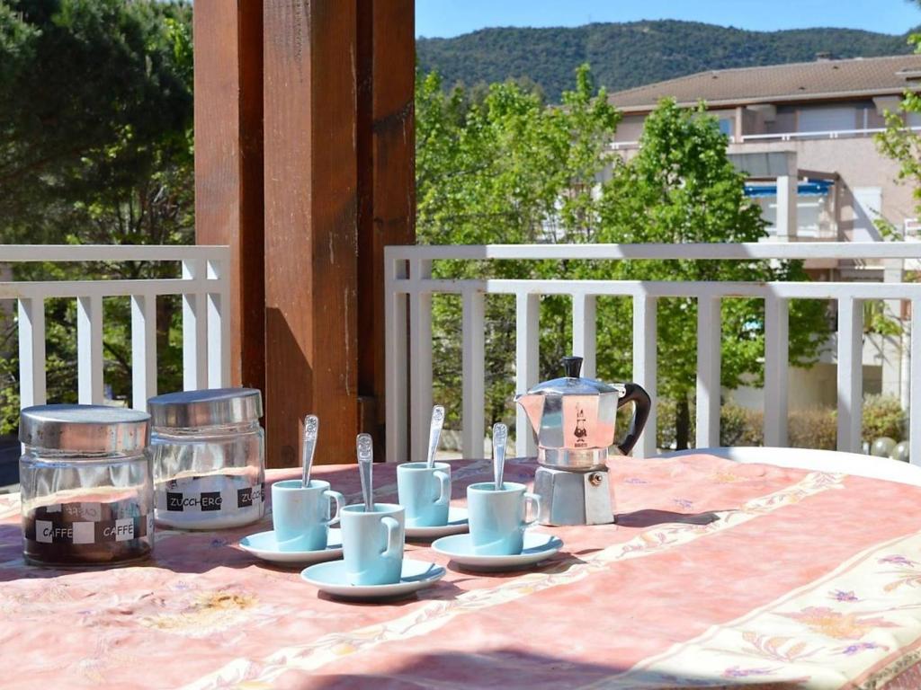 une table avec des tasses et des soucoupes au-dessus d'une table dans l'établissement Appartement Duplex avec Terrasse, 2 Chambres, Parking Privé à 2 Min de la Plage - FR-1-251-569, au Lavandou