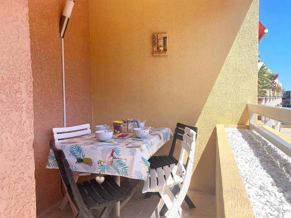 une table et des chaises assises sur un balcon avec une table dans l'établissement Appartement rénové, 2 pièces, climatisé, garage, balcon, à 350m de la plage - Bormes-les-Mimosas - FR-1-251-526, à Bormes-les-Mimosas