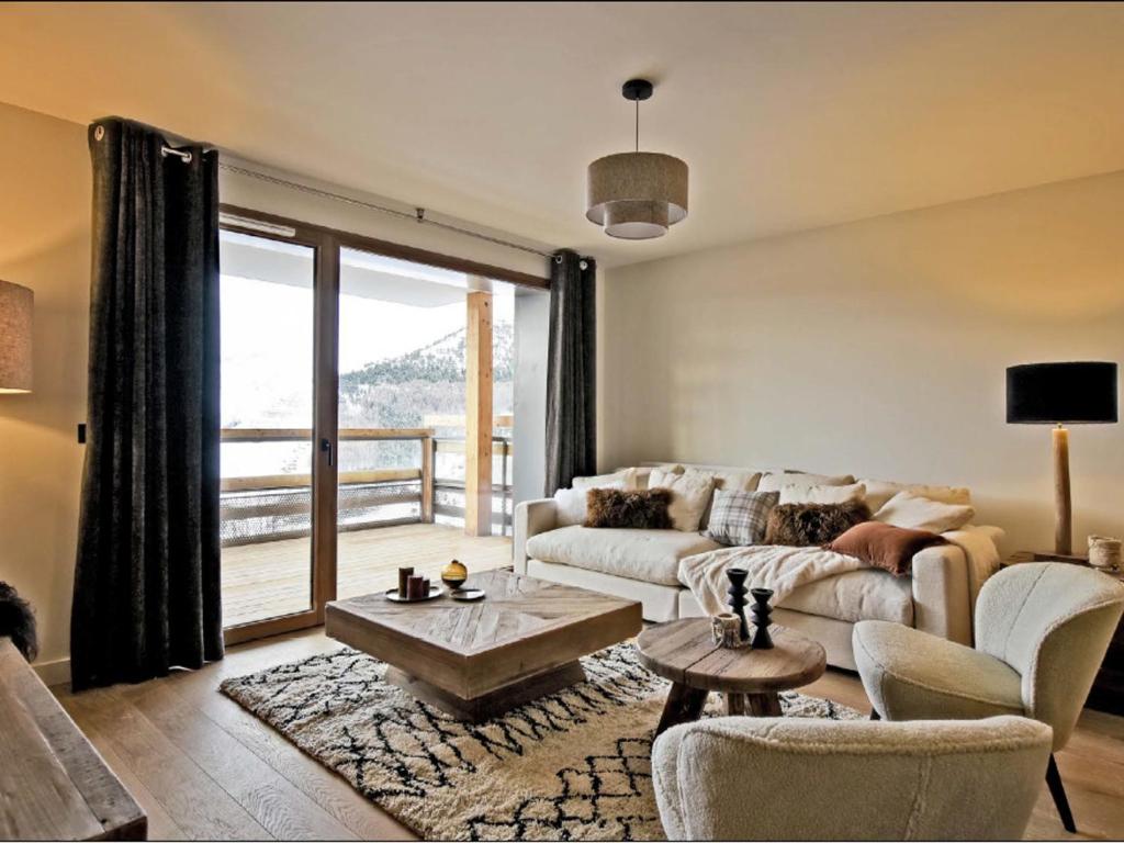 a living room with a couch and a table at Appartement Huez, 2 pièces, 2 personnes - FR-1-645-60 in LʼHuez